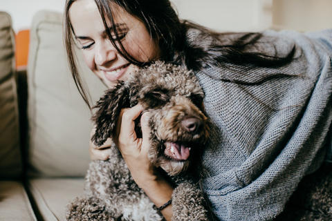 Frau kuschelt ihren Hund